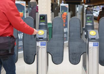 Person passing through ticket gates at a London railway station