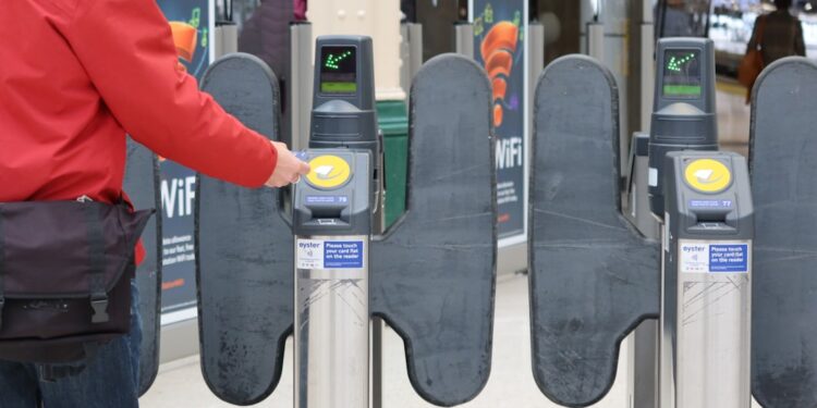 Person passing through ticket gates at a London railway station