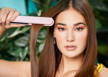 A woman gracefully styles her sleek hair with a TYMO Hair Flat Iron, framed by a lush.
