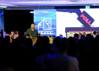 Marketing keynote speaker delivering a high-impact presentation at a business conference. The event highlights innovation, audience engagement, and modern brand strategy.