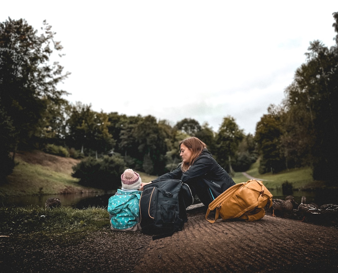 Mother and daughter sitting by a lake