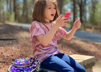 Juliana has a happy reaction about something on her phone.