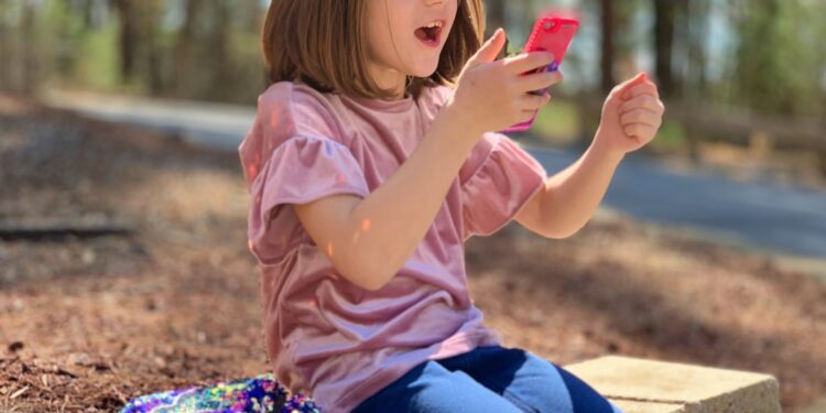 Juliana has a happy reaction about something on her phone.