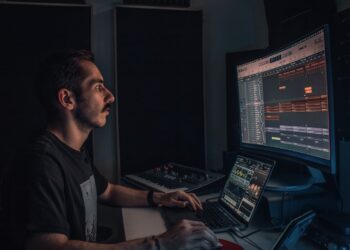 Young music producer in home studio at night