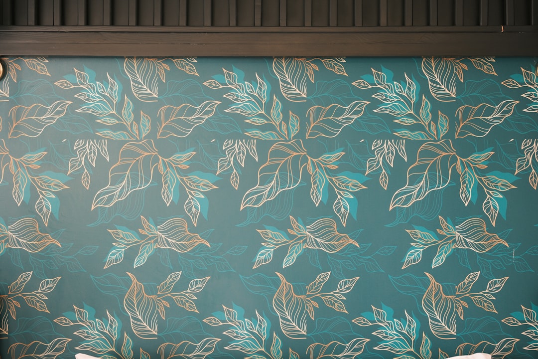Teal wallpaper with a repeating leaf and fish pattern