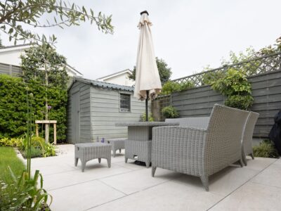 A patio with a table and chairs and an umbrella