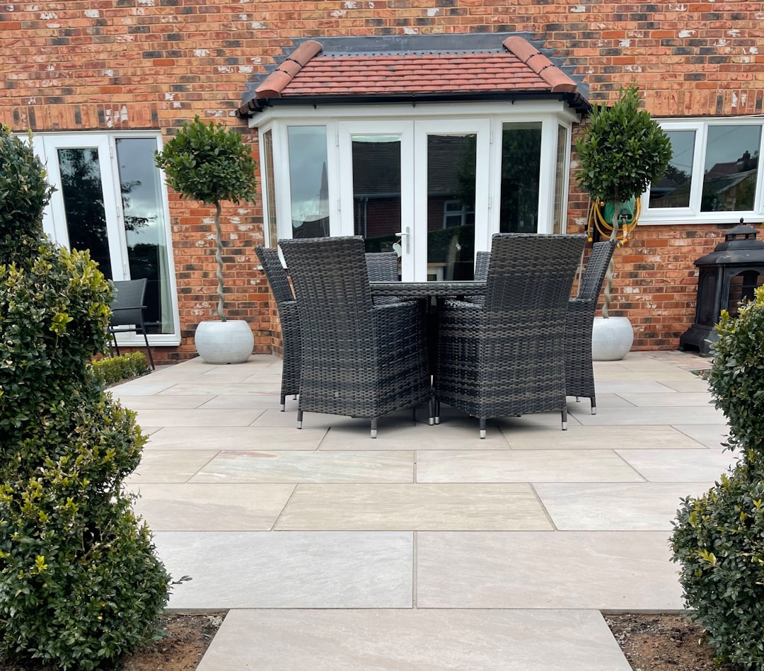 a patio with a table and chairs in front of a brick building