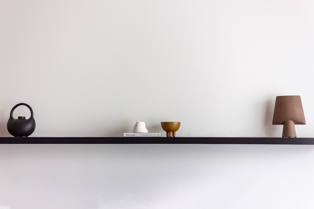 a shelf with two vases and a lamp on it